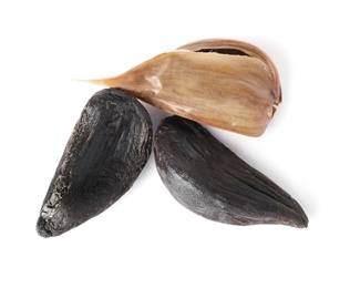 Photo of Cloves of aged black garlic on white background, view from above
