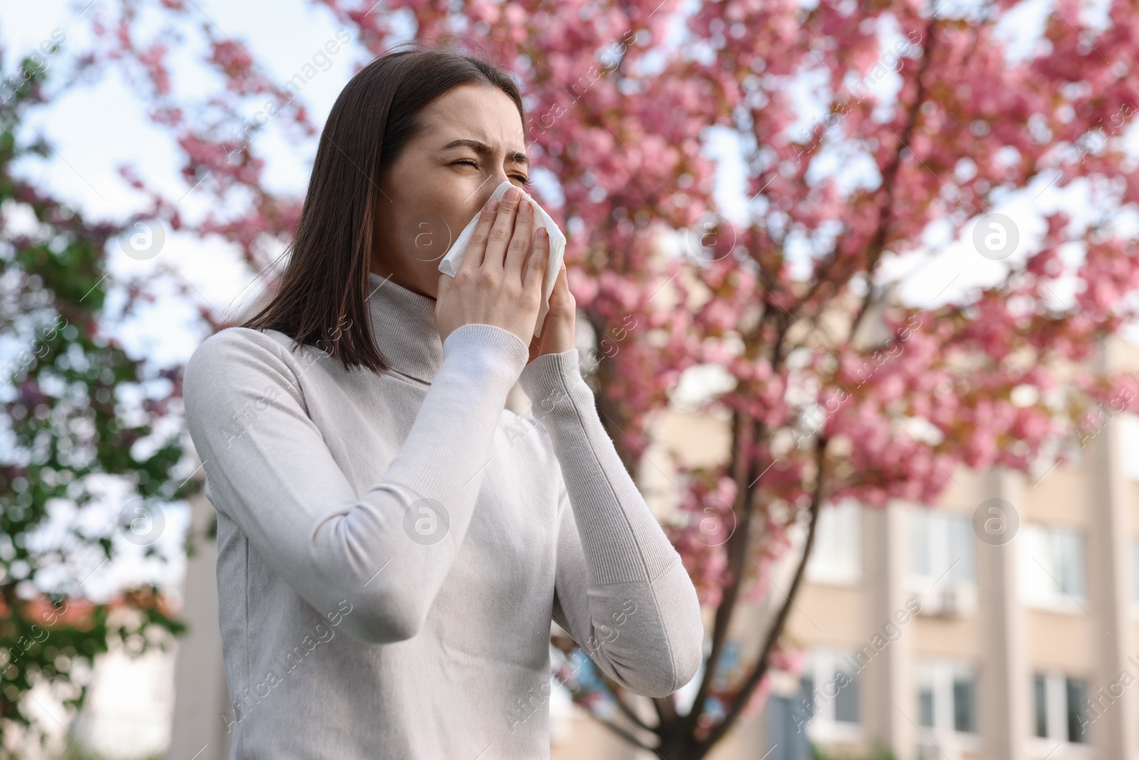 Photo of Woman with napkin suffering from seasonal allergy on spring day