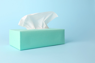 Photo of Box of paper tissues on light blue background