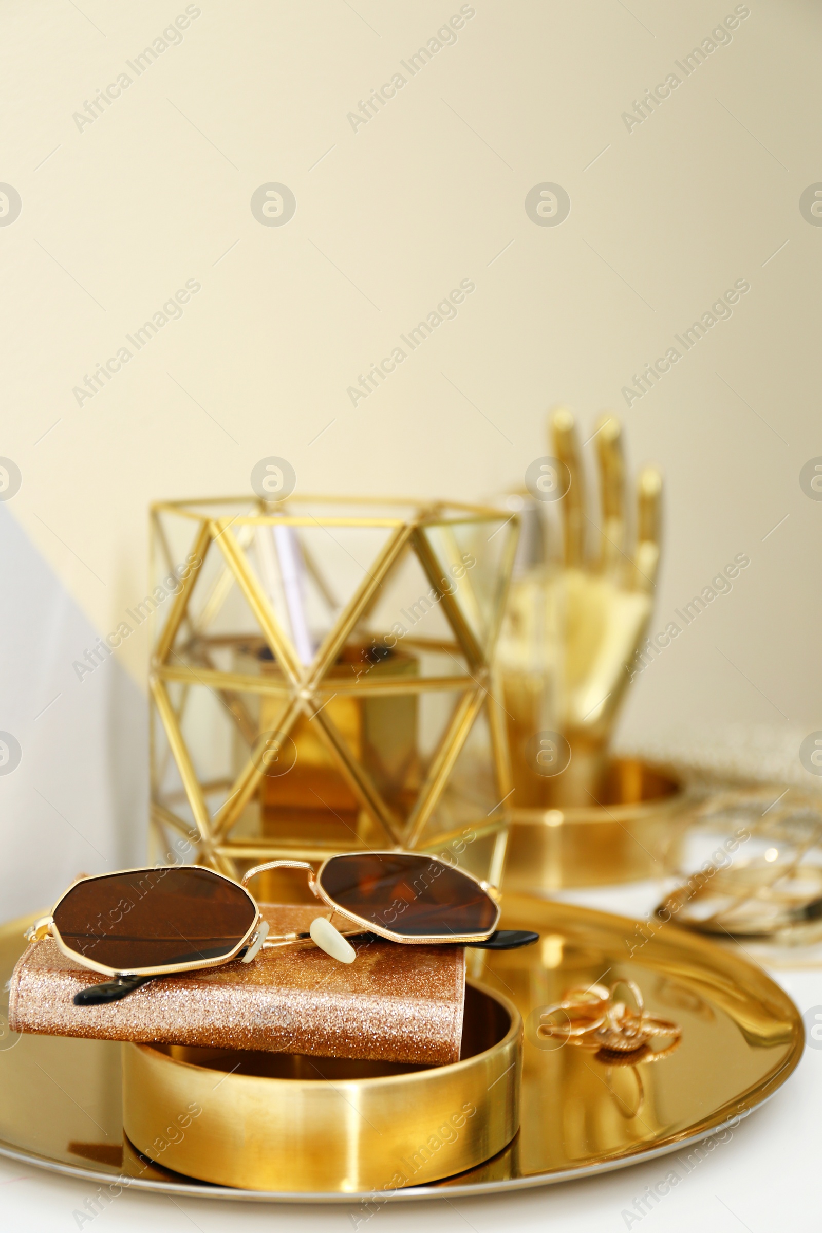 Photo of Gold tray with notebook, glasses and accessories on dressing table. Space for text