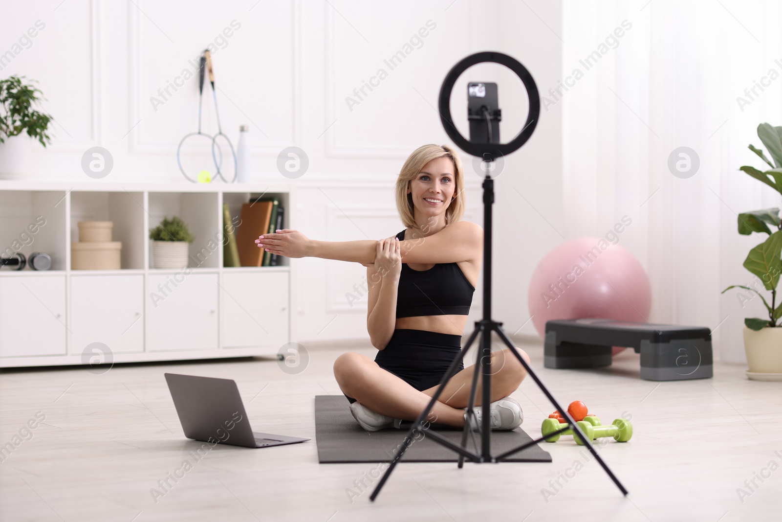 Photo of Smiling sports blogger streaming online fitness lesson at home