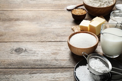 Photo of Fresh ingredients for delicious homemade cake on wooden table. Space for text