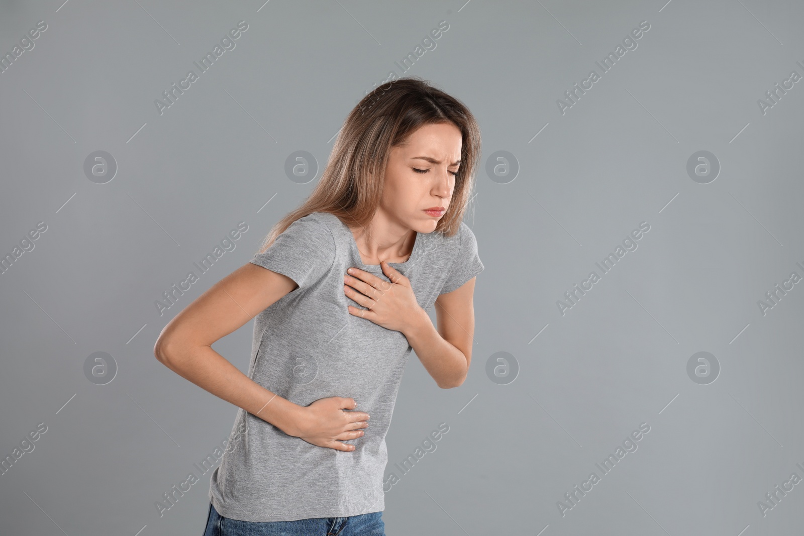 Photo of Woman suffering from nausea on grey background, space for text. Food poisoning