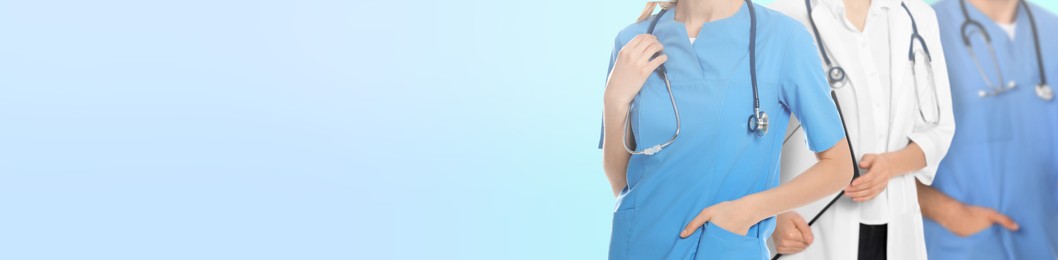 Image of Doctors and nurse on light blue background, closeup. Banner design with space for text