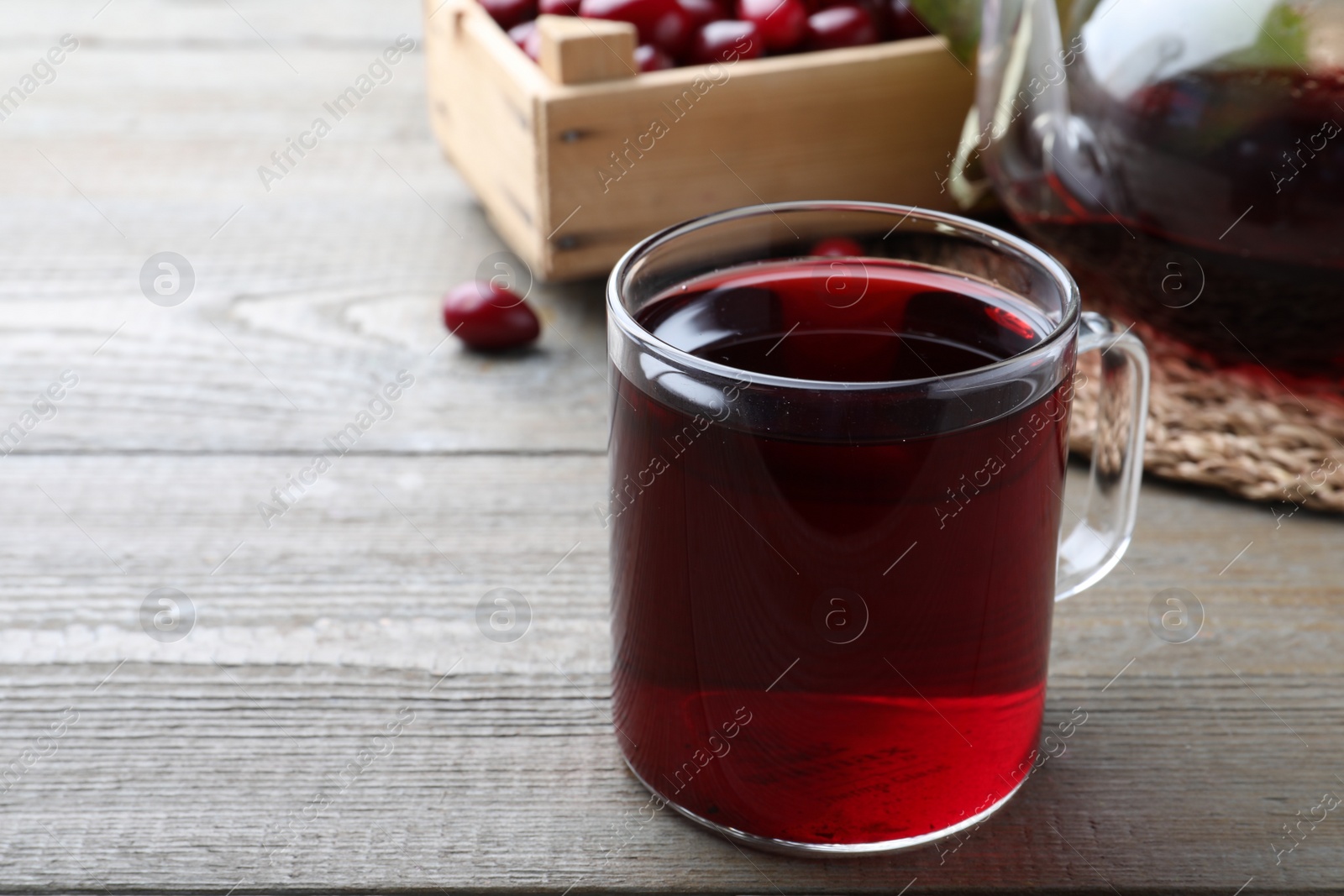 Photo of Glass cup of fresh dogwood tea on wooden table. Space for text