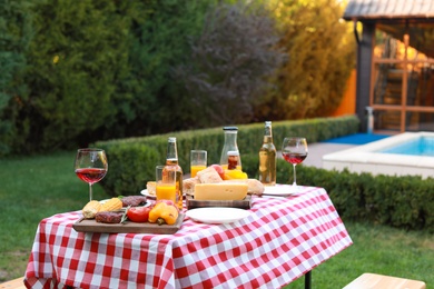 Table with delicious food and drinks outdoors. Barbecue party