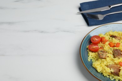 Photo of Delicious pilaf with meat served on white marble table, space for text