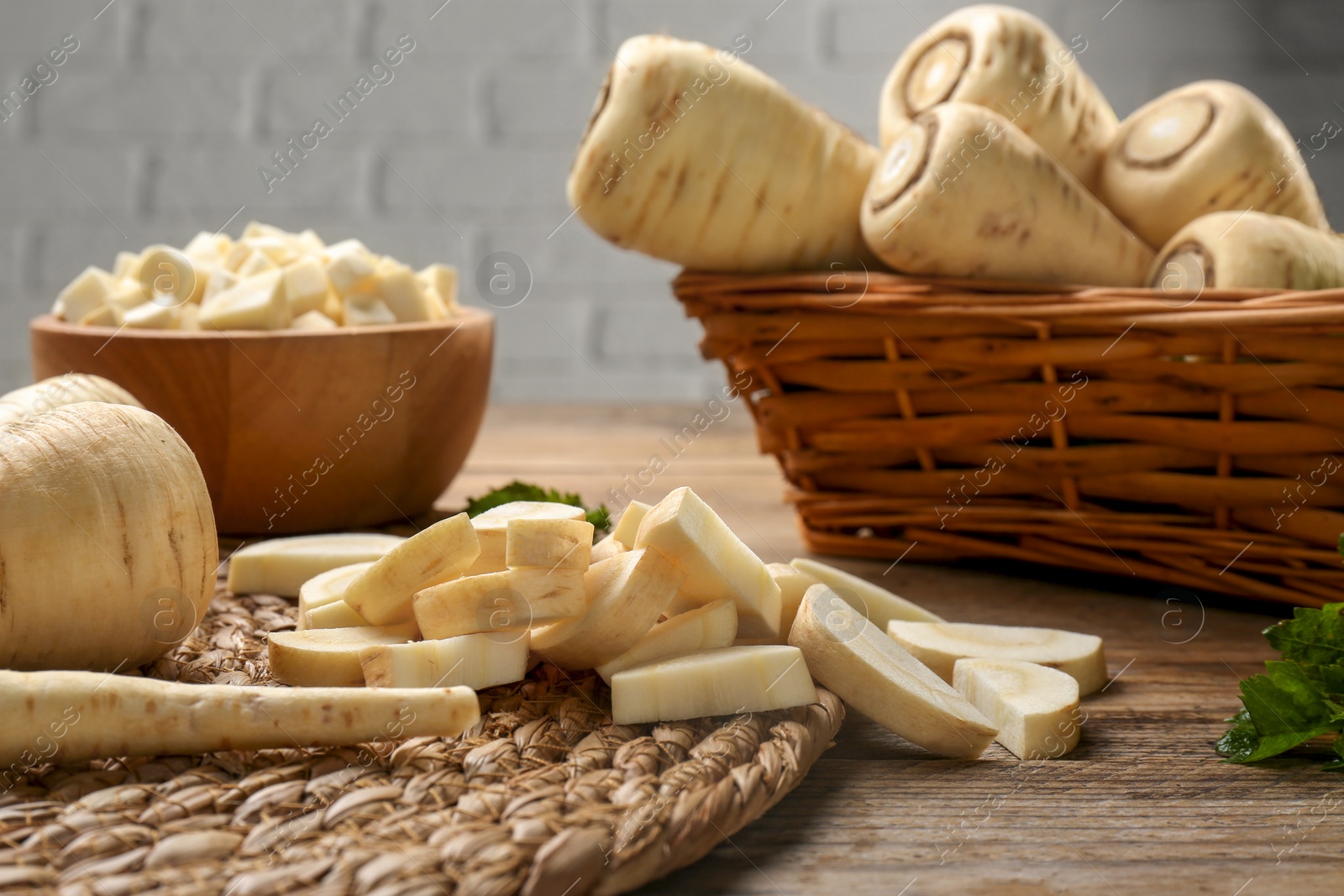 Photo of Whole and cut parsnips on wooden table