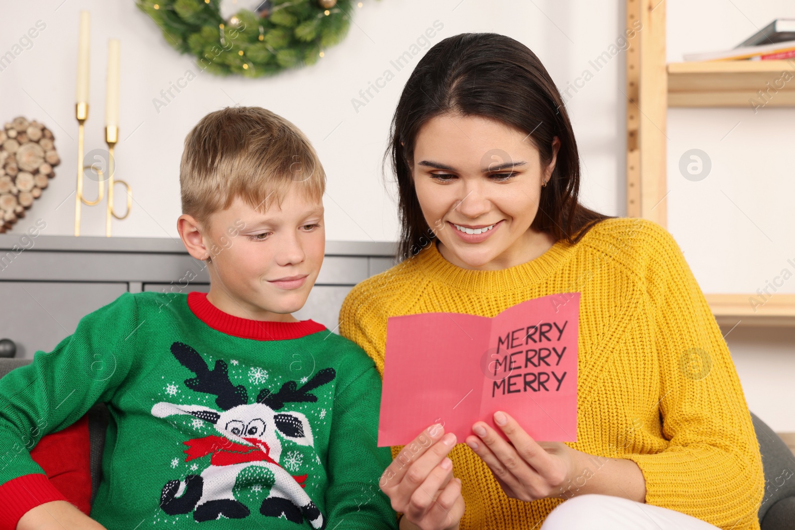 Photo of Happy woman receiving greeting card from her son at home