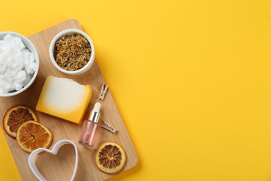 Photo of Flat lay composition with natural handmade soap and ingredients on yellow background. Space for text
