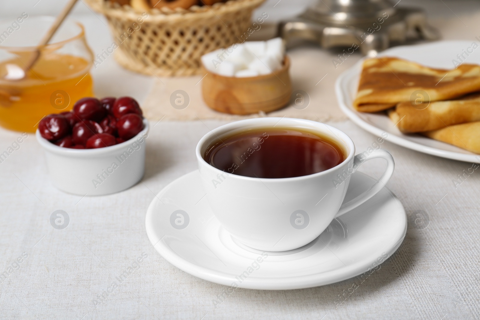 Photo of Cup of aromatic tea and treats on table