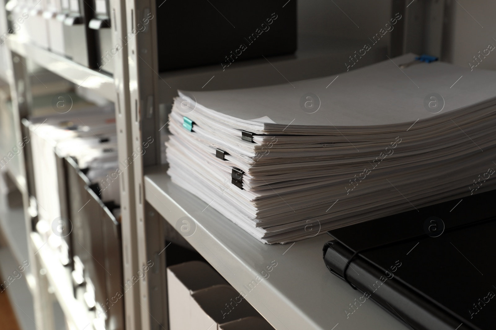 Photo of Stack of documents with paper clips on shelf in office