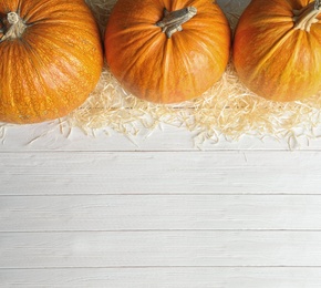 Photo of Orange pumpkins on wooden background, flat lay composition with space for text. Autumn holidays