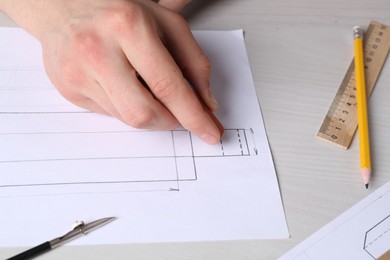 Photo of Man creating packaging design at light wooden table, closeup