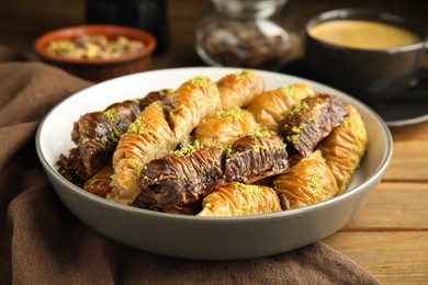 Delicious sweet baklava in bowl wooden table, closeup