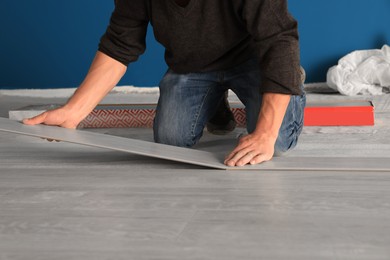 Professional worker installing new laminate flooring indoors