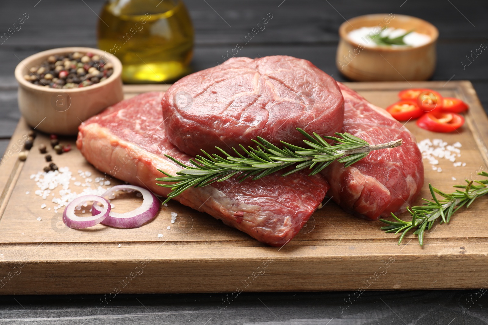 Photo of Pieces of raw beef meat and spices on table, closeup