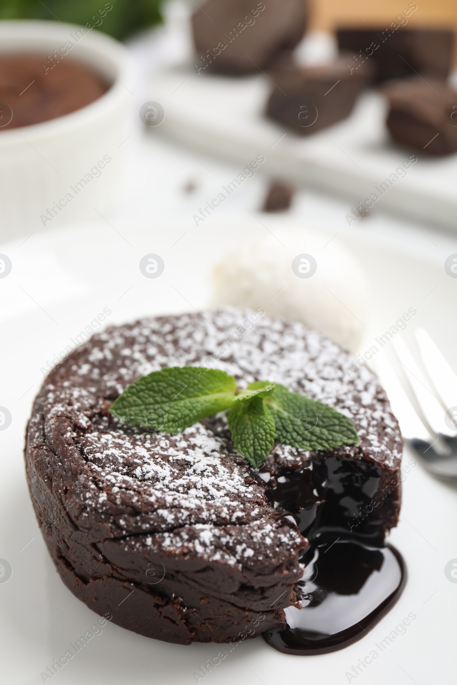 Photo of Delicious fresh fondant with hot chocolate, mint and ice cream served on white table, closeup