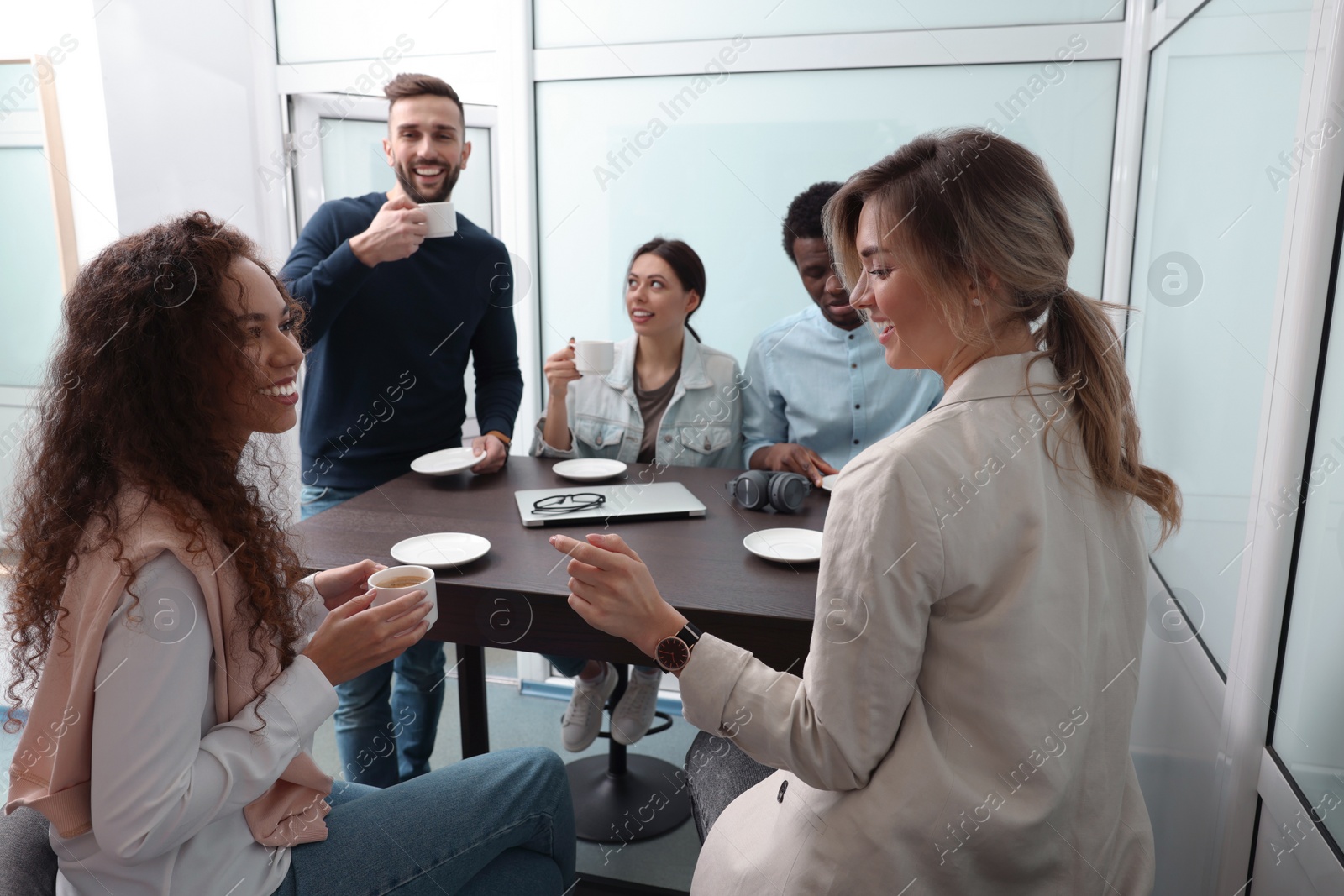 Photo of Team of employees enjoying coffee break together in office. Startup project