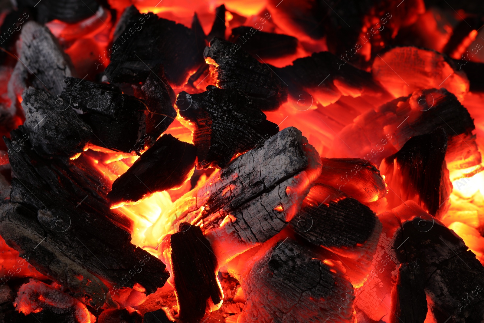 Photo of Pieces of hot smoldering coal as background, closeup