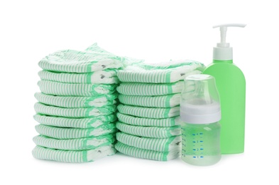 Photo of Stacks of diapers and baby accessories on white background