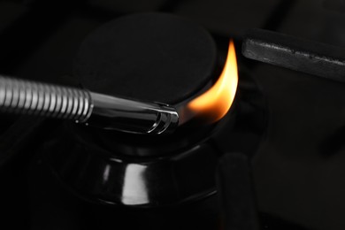 Photo of Lighting stove with gas lighter, closeup view