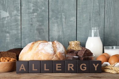 Photo of Different products on wooden background. Food allergy concept