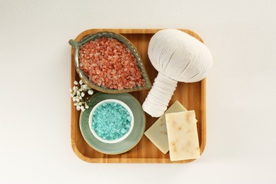 Photo of Aromatic sea salt, beautiful flowers and different spa products on white table, top view