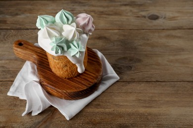 Traditional Easter cake decorated with meringues on wooden table, space for text