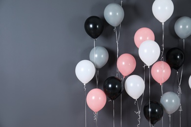 Photo of Bright balloons near color wall. Space for text