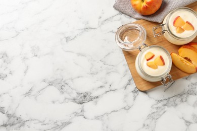 Photo of Delicious yogurt with fresh peach on white marble table, flat lay. Space for text