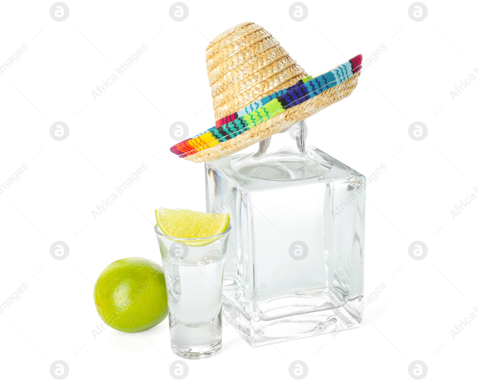 Photo of Mexican sombrero hat, tequila and limes isolated on white