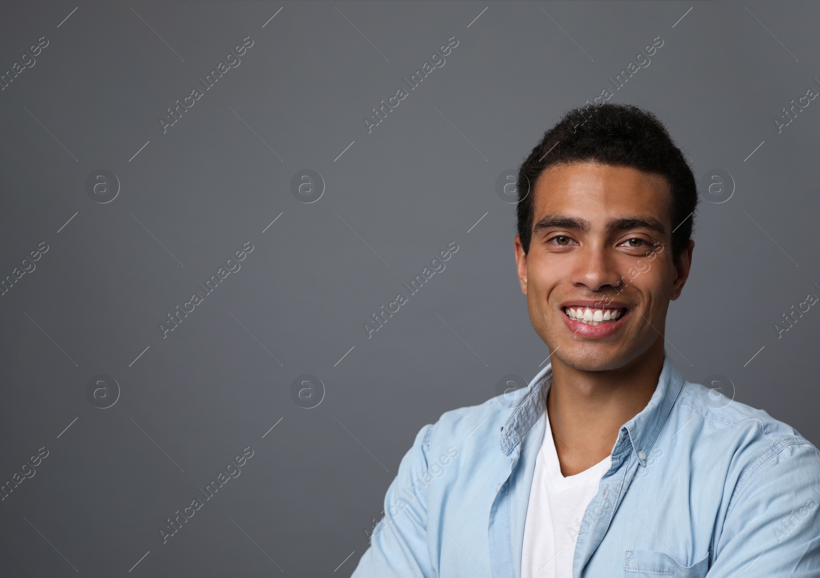 Photo of Handsome young African-American man on grey background. Space for text