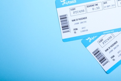 Photo of Avia tickets on light blue background, flat lay with space for text. Travel agency concept