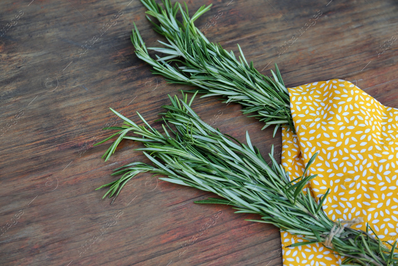 Photo of Bunches of fresh rosemary on wooden table. Aromatic herb