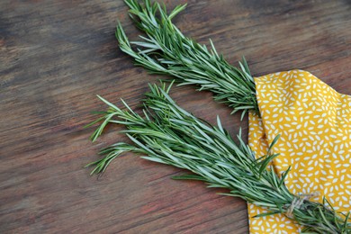 Photo of Bunches of fresh rosemary on wooden table. Aromatic herb