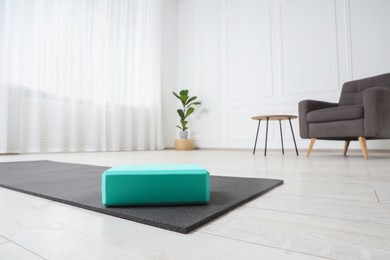 Photo of Exercise mat and yoga block indoors, low angle view