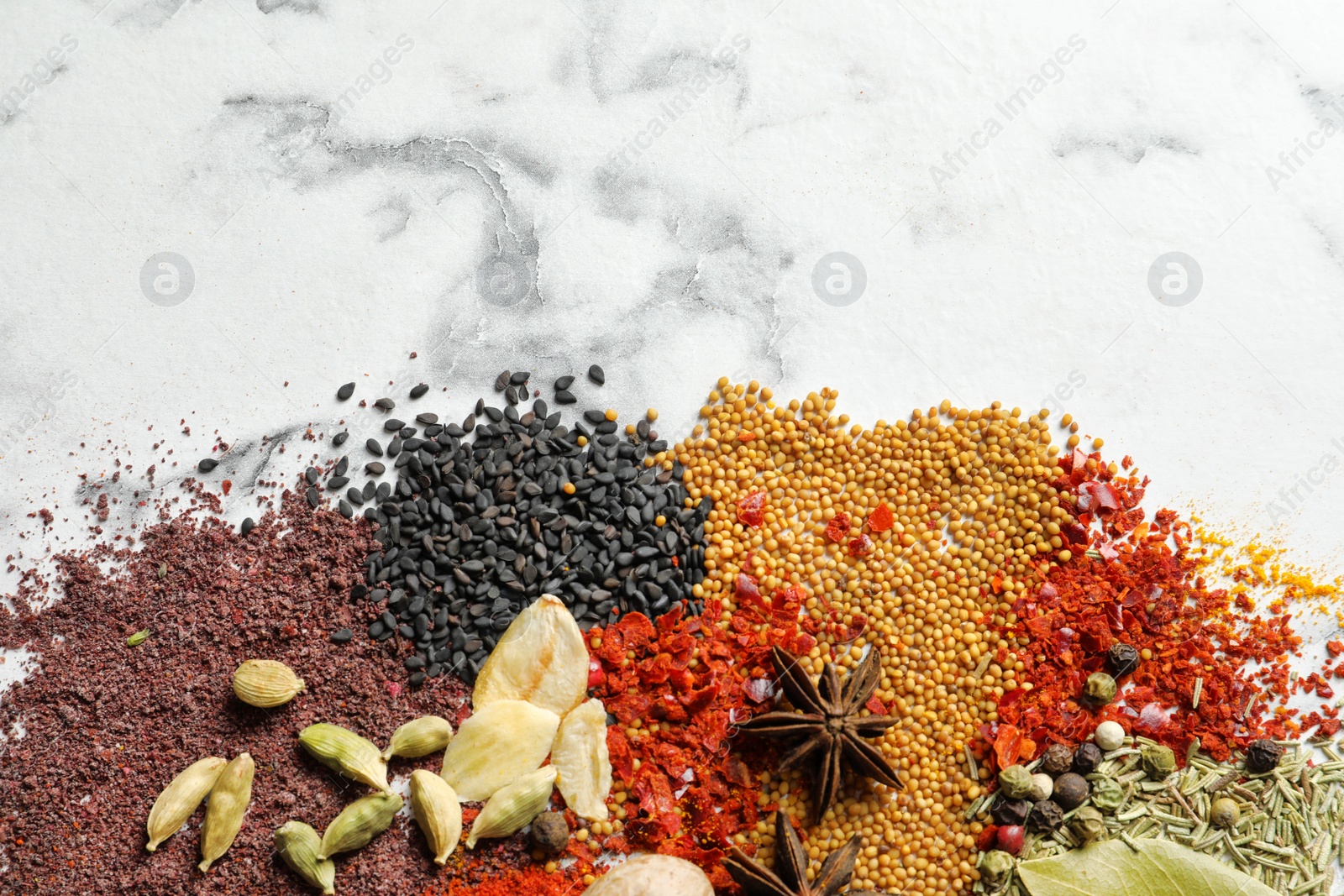 Photo of Different aromatic spices on marble background, top view with space for text