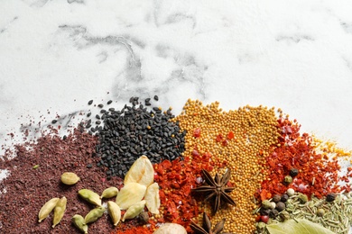 Different aromatic spices on marble background, top view with space for text