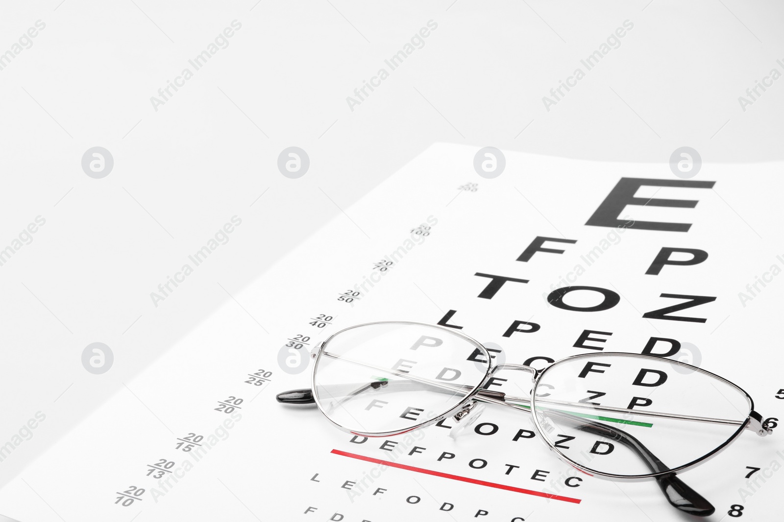 Photo of Glasses and vision test chart isolated on white