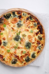 Photo of Delicious homemade quiche with salmon and broccoli on white table, top view