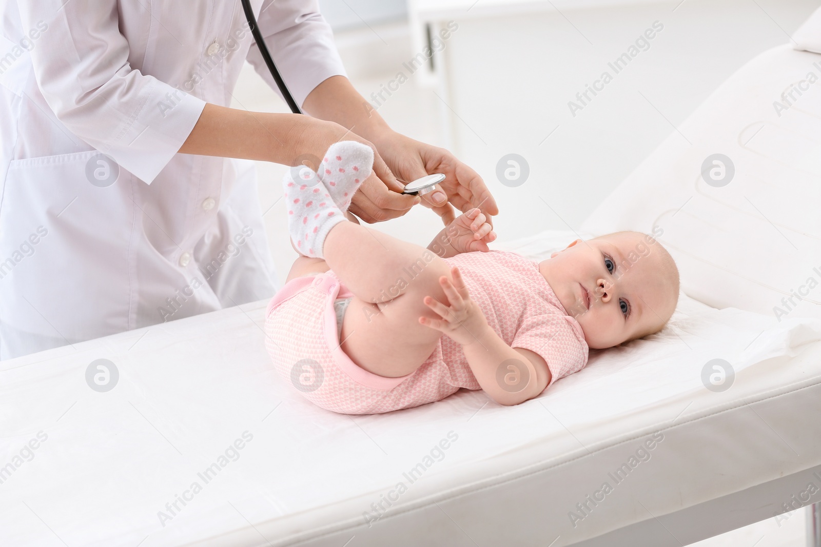 Photo of Children's doctor examining baby with stethoscope in hospital