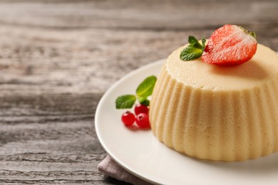 Delicious semolina pudding with berries on wooden table, space for text