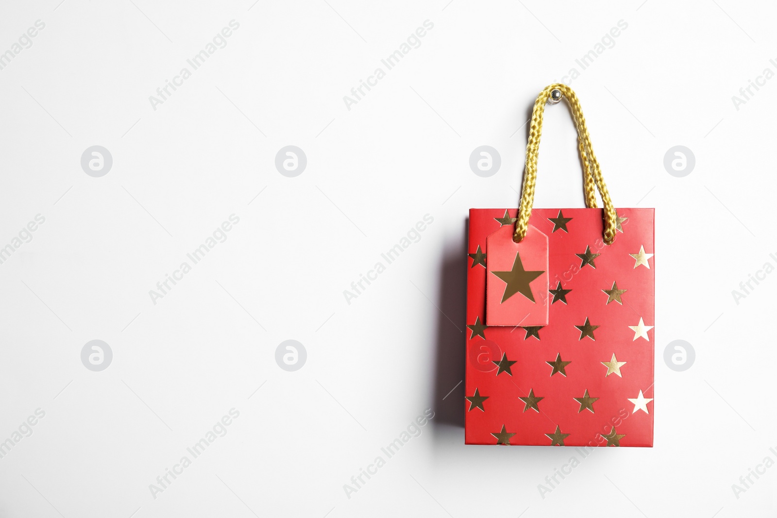 Photo of Red shopping paper bag with star pattern isolated on white