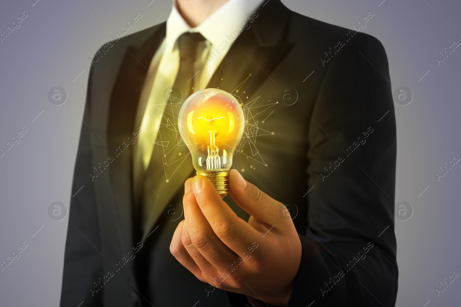 Image of Glow up your ideas. Businessman holding light bulb on grey background, closeup