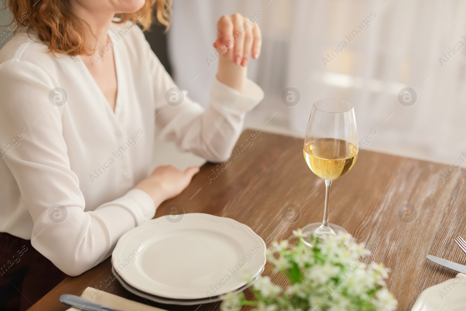 Photo of Woman with glass of wine at table in restaurant