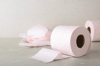 Roll of toilet paper on grey table. Space for text