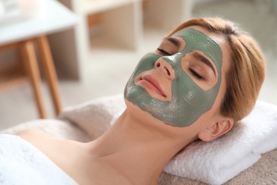 Photo of Beautiful woman with mask on face relaxing in spa salon