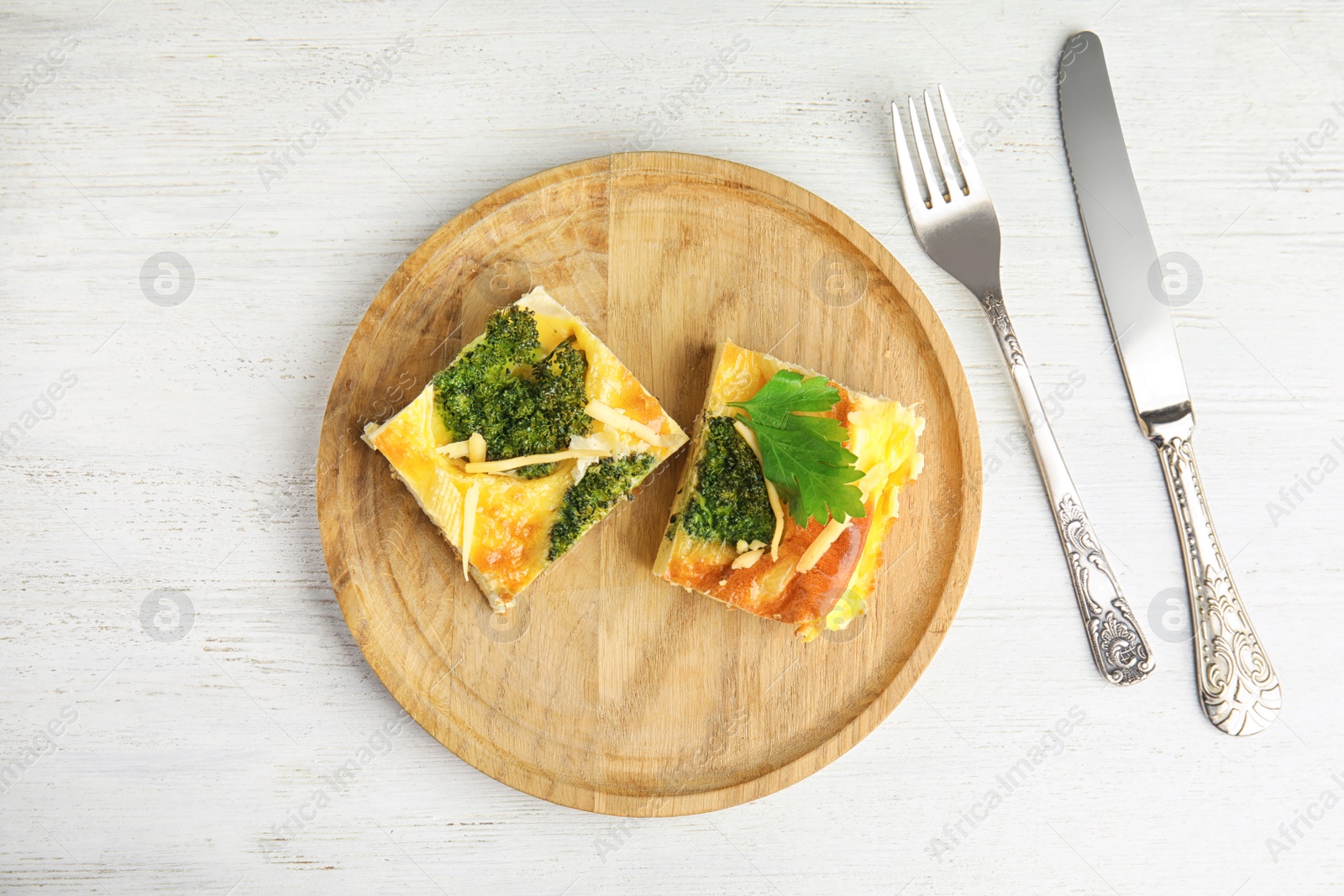Photo of Tasty broccoli casserole served on white wooden table, flat lay