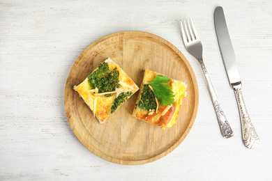 Tasty broccoli casserole served on white wooden table, flat lay